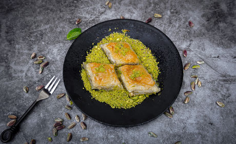 Pistachio baklava on a black plate